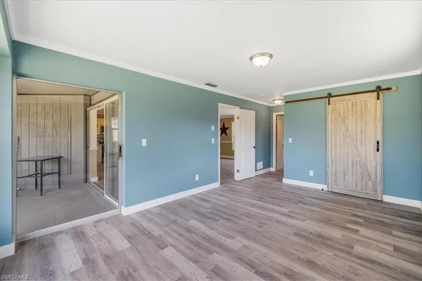 a view of a livingroom with wooden floor and a bathroom