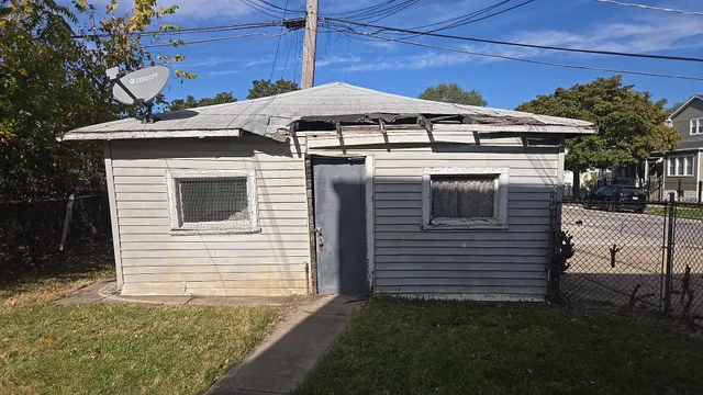 a view of a white house with a yard and potted plants