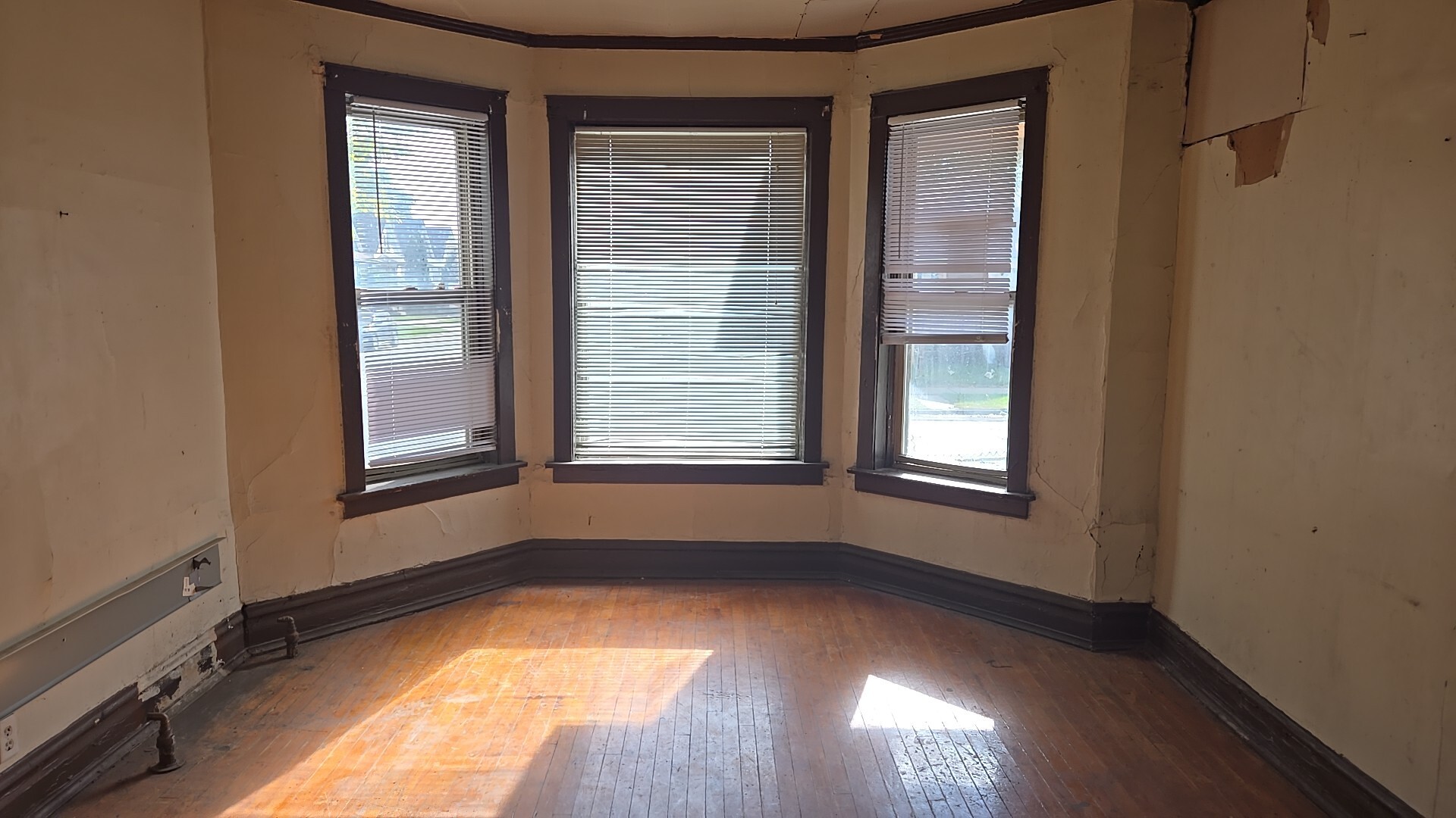 134 West 107th Street Chicago, IL 60628 - Photo 7 of 24 a view of an empty room with wooden floor and a window