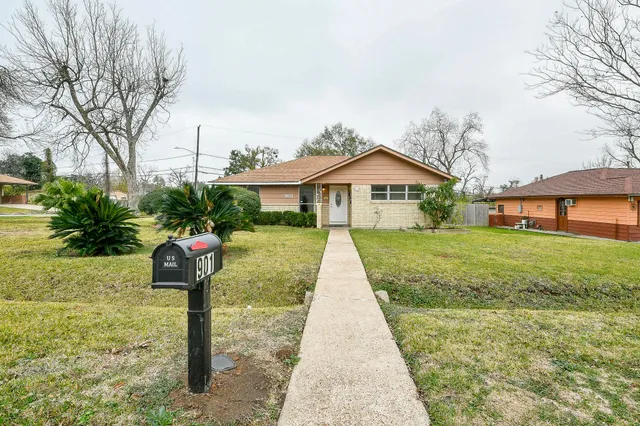 a front view of a house with a yard and potted plants
