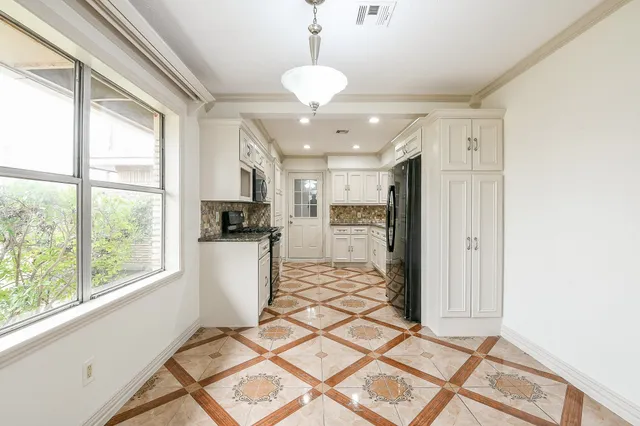 a kitchen with stainless steel appliances granite countertop a refrigerator and a stove top oven
