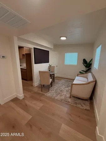 a living room with a couch and a dresser with wooden floor