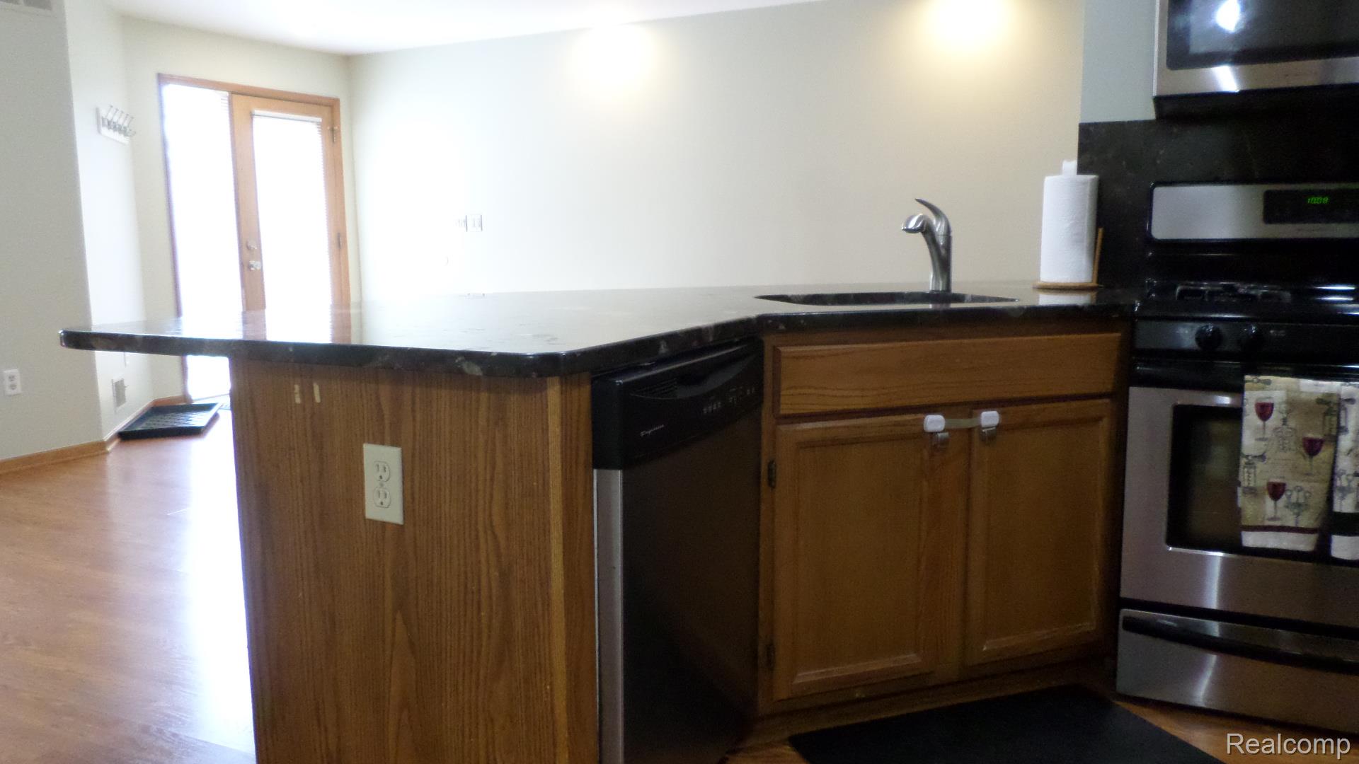 33831 Hooker Road, Unit 6 New Baltimore, MI 48047 - Photo 31 of 34 Kitchen with stainless steel appliances, wood finish cabinetry, light wood-style floors, and tasteful backsplash