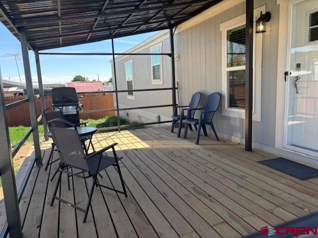 260 Southwest 13th Circle Cedaredge, CO 81413 - Photo 6 of 15 a view of a roof deck with table and chairs with wooden floor and fence