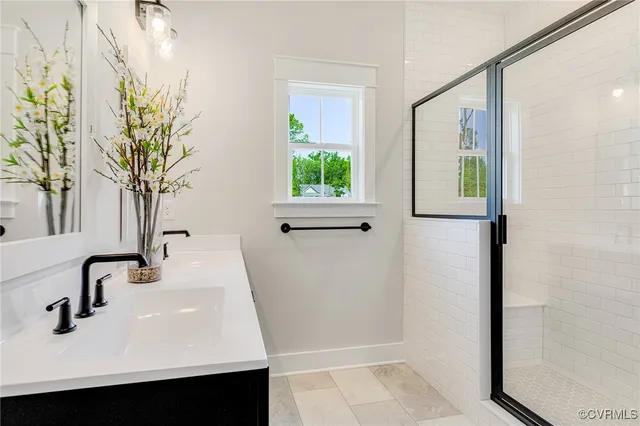 a bathroom with a double vanity sink a mirror and a window