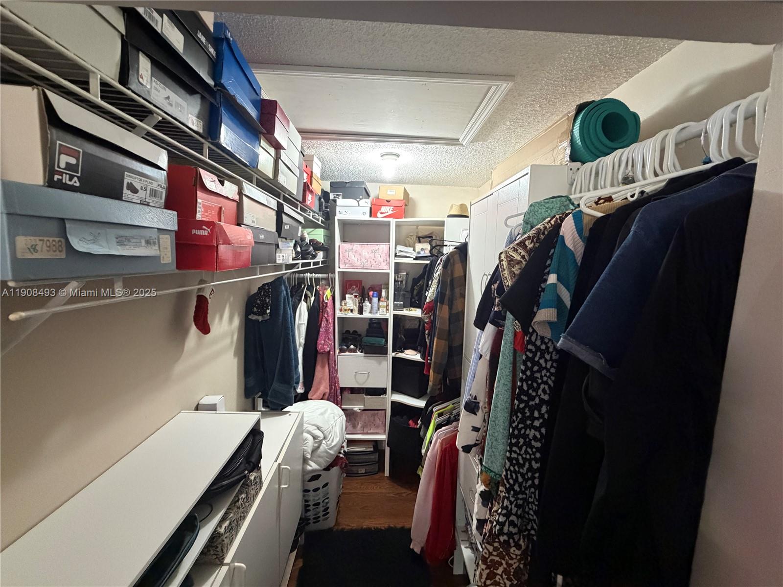 810 Northeast 212th Terrace, Unit 2 Miami, FL 33179 - Photo 26 of 44 a view of walk in closet with clothes and shoes