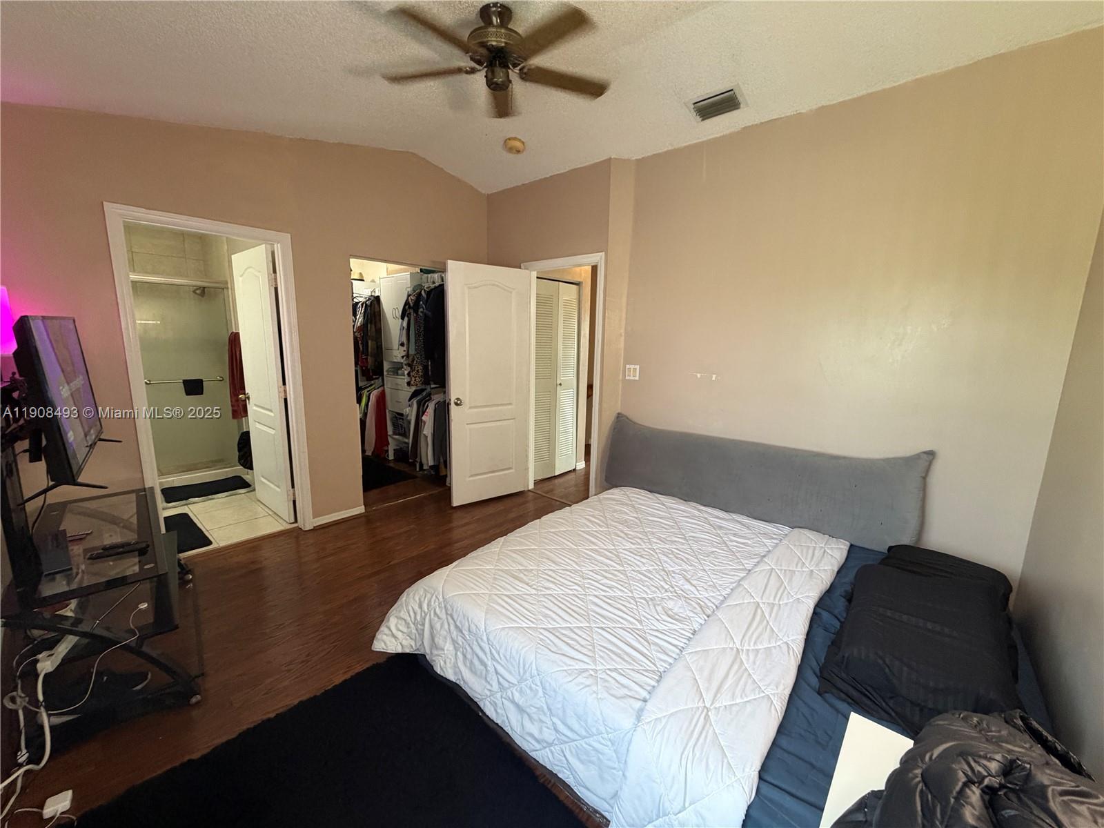 810 Northeast 212th Terrace, Unit 2 Miami, FL 33179 - Photo 27 of 44 a bedroom with a bed and a mirror