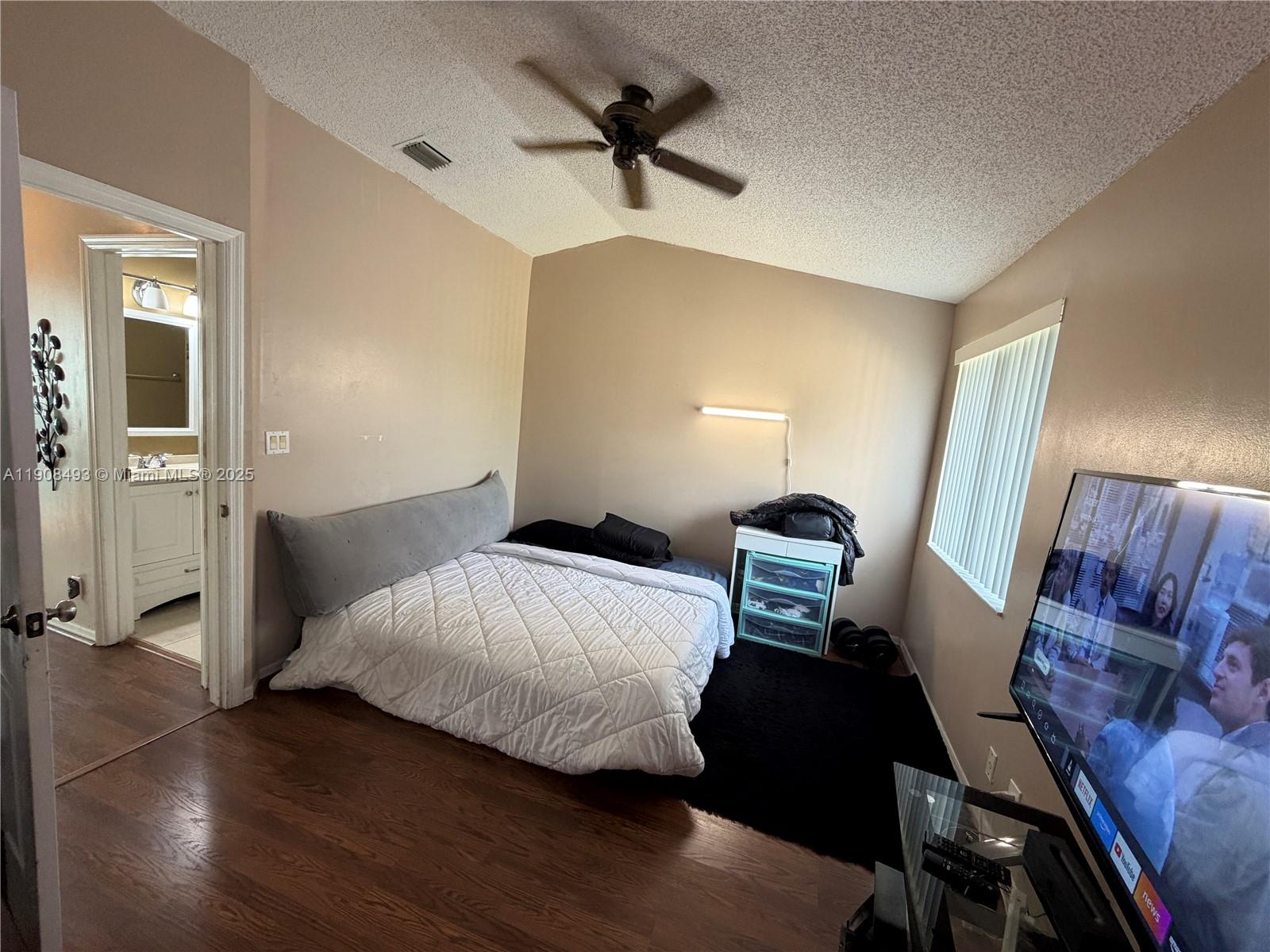 810 Northeast 212th Terrace, Unit 2 Miami, FL 33179 - Photo 28 of 44 a bedroom with a bed and a chandelier