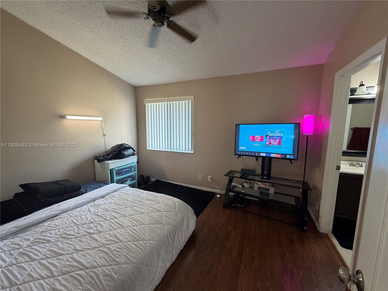 810 Northeast 212th Terrace, Unit 2 Miami, FL 33179 - Photo 29 of 44 a bedroom with a bed and a flat screen tv