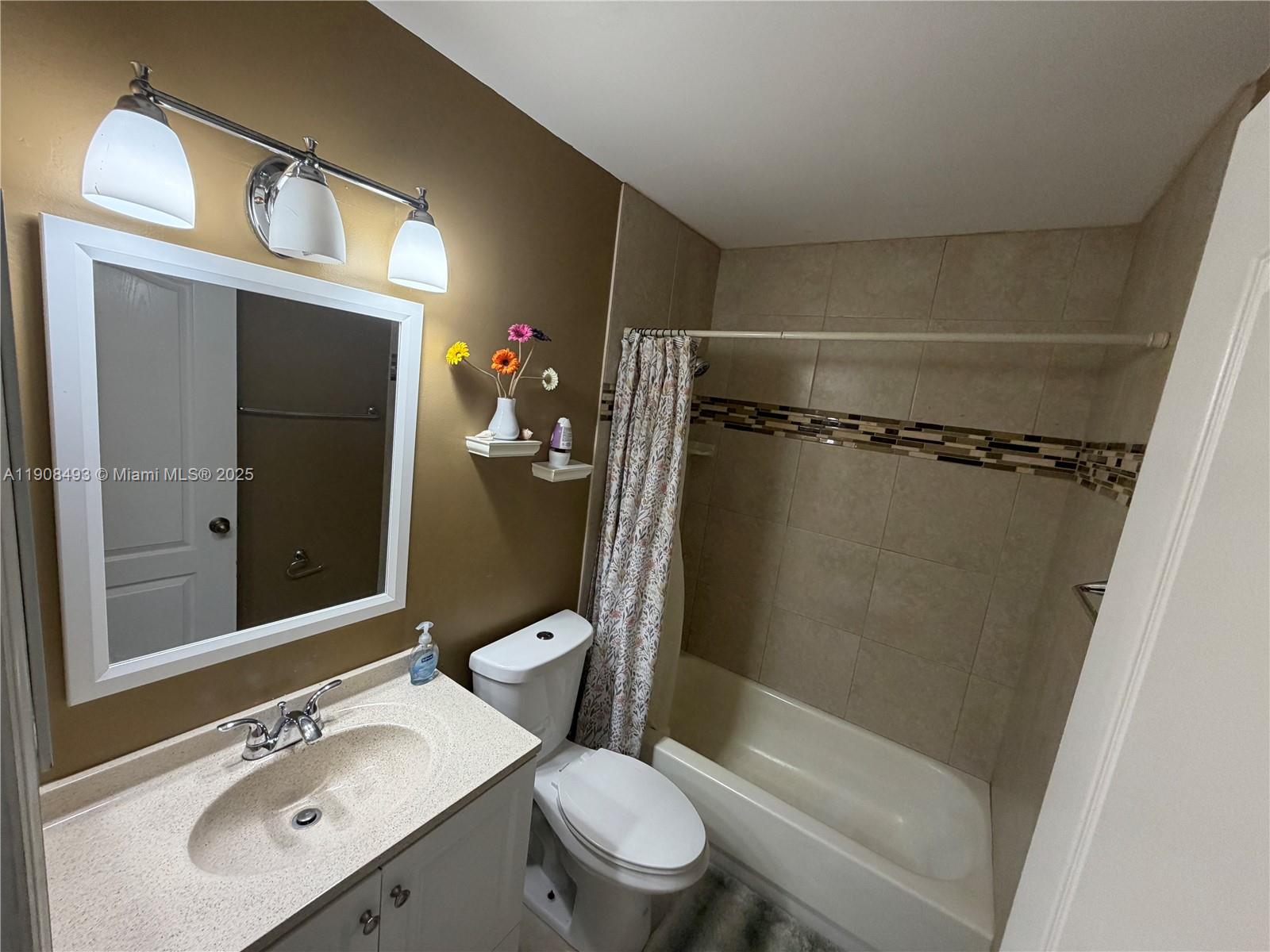 810 Northeast 212th Terrace, Unit 2 Miami, FL 33179 - Photo 30 of 44 a bathroom with a sink mirror vanity and toilet