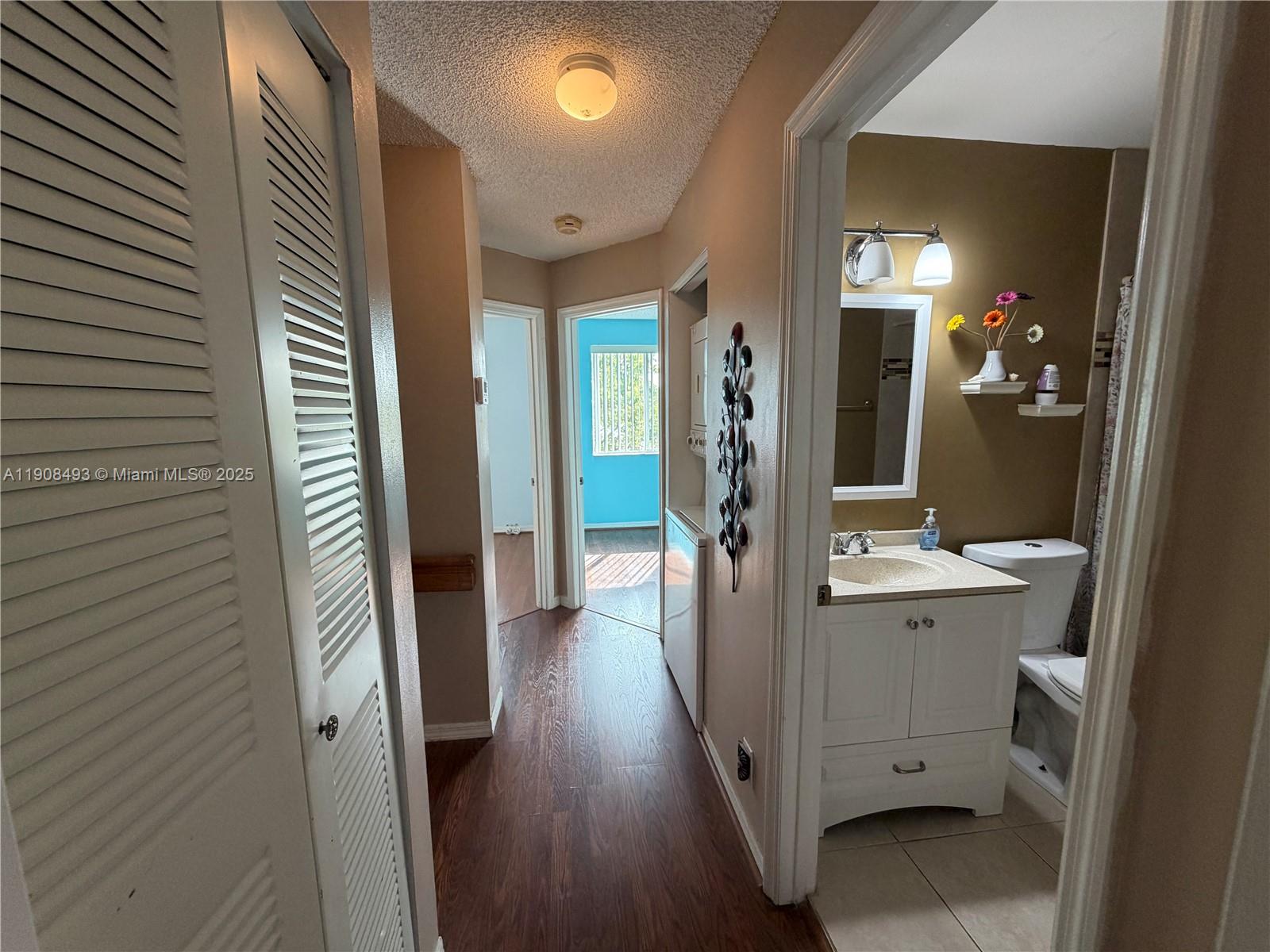 810 Northeast 212th Terrace, Unit 2 Miami, FL 33179 - Photo 34 of 44 a view of a hallway with bathroom and wooden floor