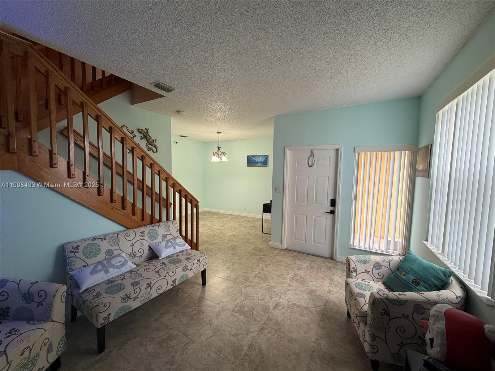 810 Northeast 212th Terrace, Unit 2 Miami, FL 33179 - Photo 5 of 44 a living room with furniture and stairs