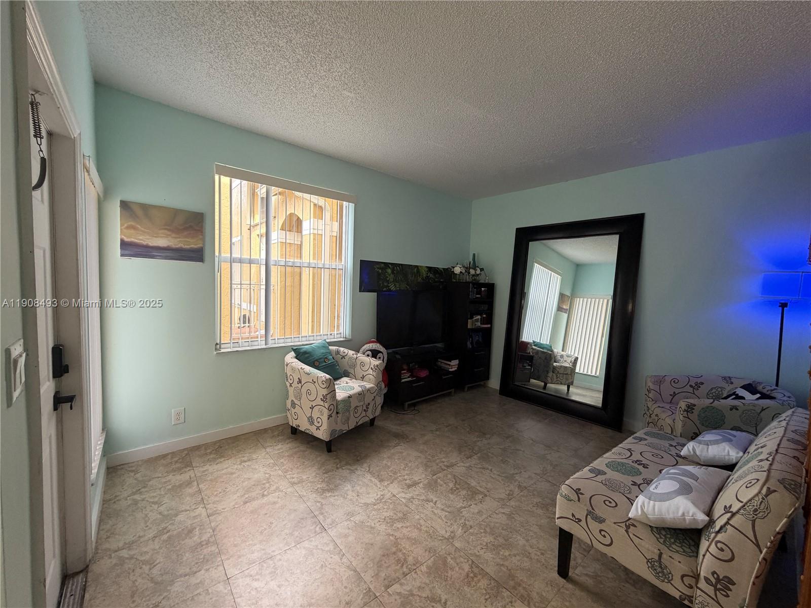 810 Northeast 212th Terrace, Unit 2 Miami, FL 33179 - Photo 6 of 44 a living room with furniture and a window