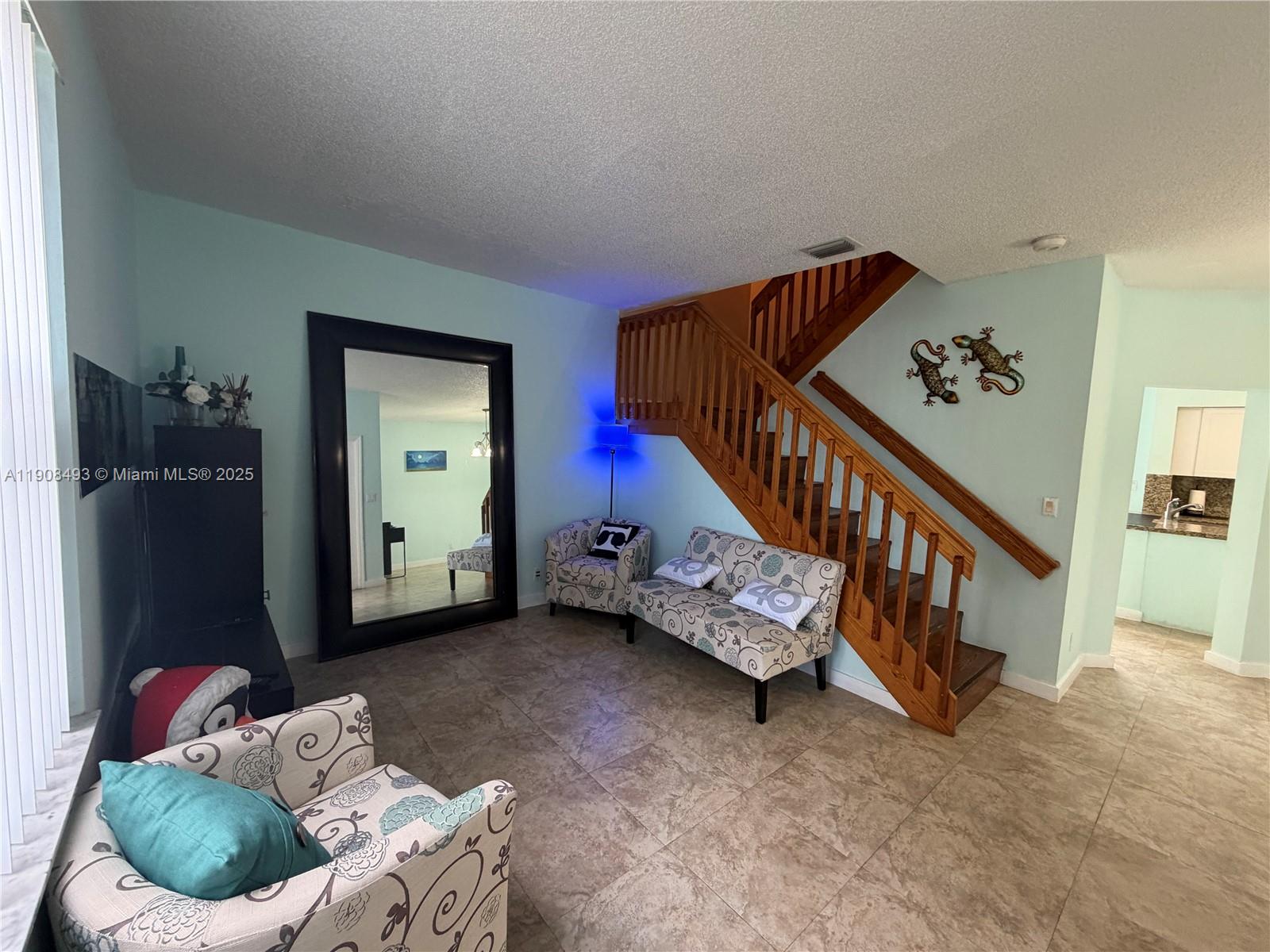 810 Northeast 212th Terrace, Unit 2 Miami, FL 33179 - Photo 7 of 44 a living room with furniture and stairs