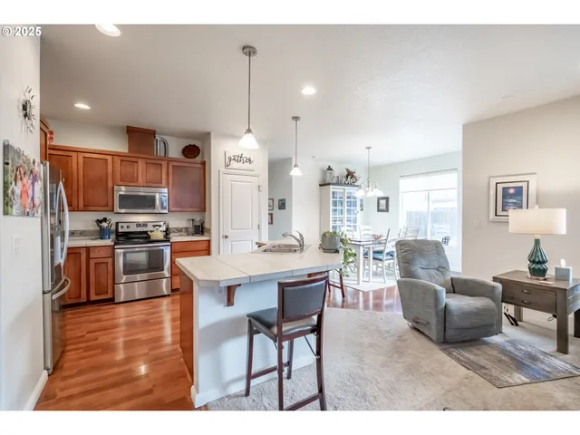 a living room with furniture and a dining table with kitchen view