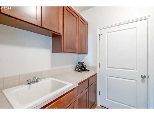 a spacious bedroom with a bed and a flat tv screen on dresser