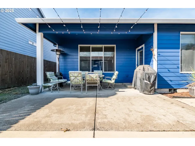 a view of a patio with table and chairs with wooden fence