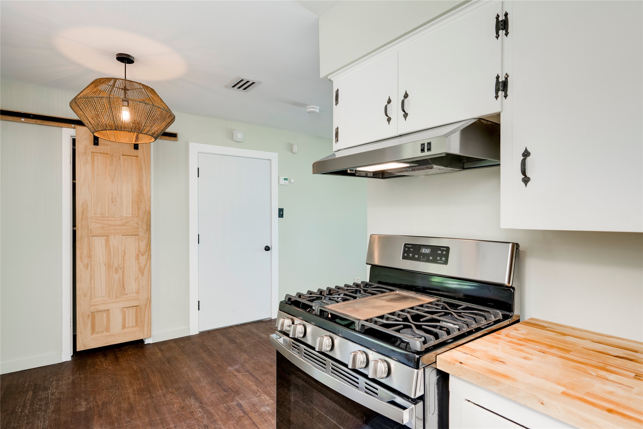 1707 Overhill Drive Austin, TX 78721 - Photo 10 of 36 Modern kitchen with stainless steel appliances and warm wood flooring awaits your culinary creations.