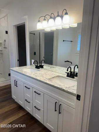 a bathroom with a granite countertop sink and a mirror