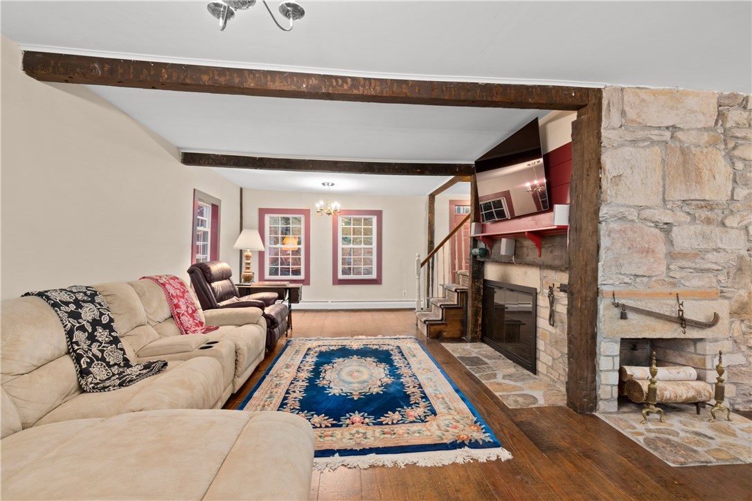 422 Waterman Hill Road Coventry, RI 02827 - Photo 16 of 39 Living Room - notice the warm and beautiful large plank pine floors as well as another fireplace to the right. This area is part of the original home built circa 1855.