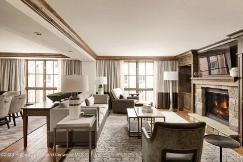 a living room with furniture a fireplace and a large window