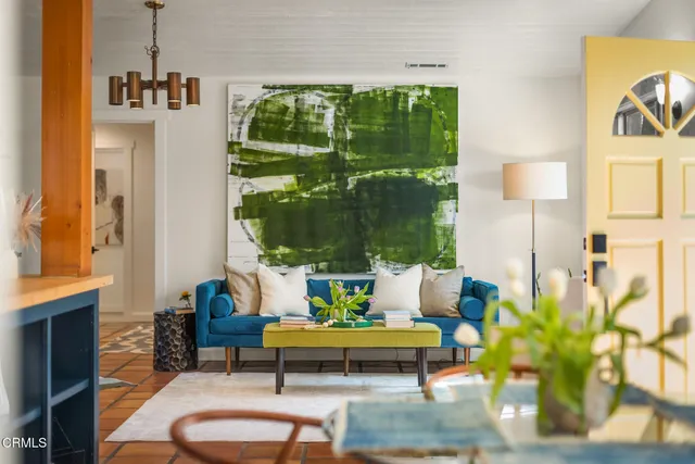 a living room with patio furniture and a potted plant