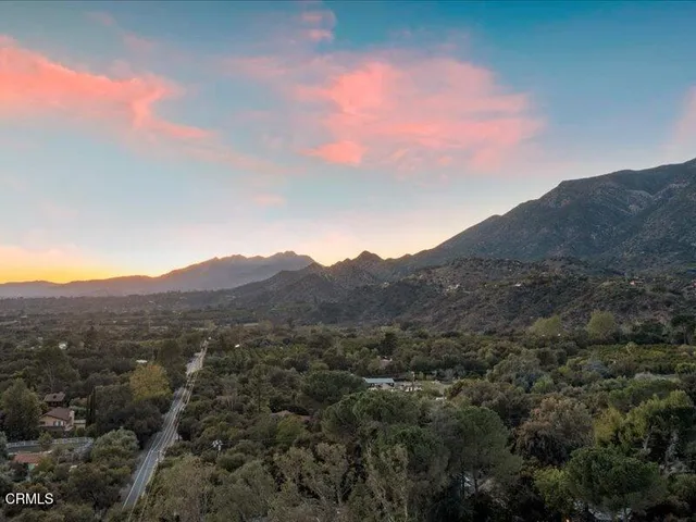 a view of a mountain range with lush green forest