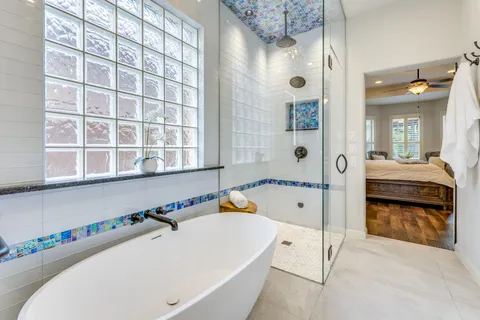 a bathroom with a tub a sink and a large mirror