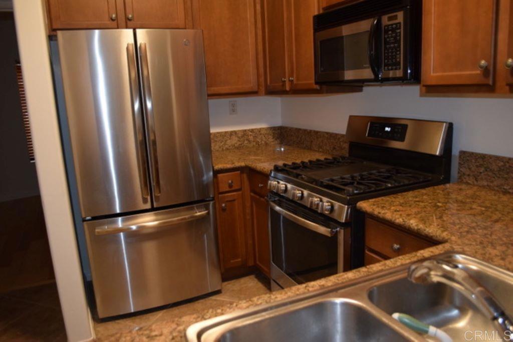 366 Forward Street, Unit E La Jolla, CA 92037 - Photo 1 of 26 a kitchen with granite countertop a refrigerator stove and microwave