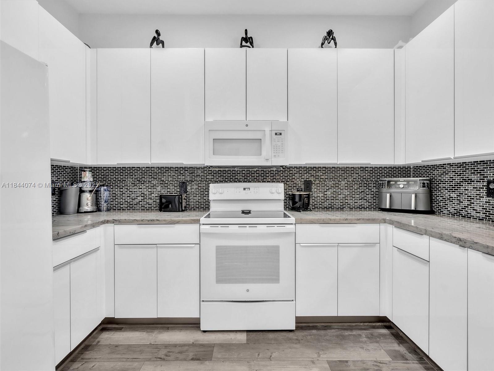 4331 Southwest 124th Way Miramar, FL 33027 - Photo 11 of 58 a kitchen with white cabinets and white appliances