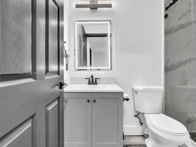 a bedroom with a bed a flat screen tv and a chandelier