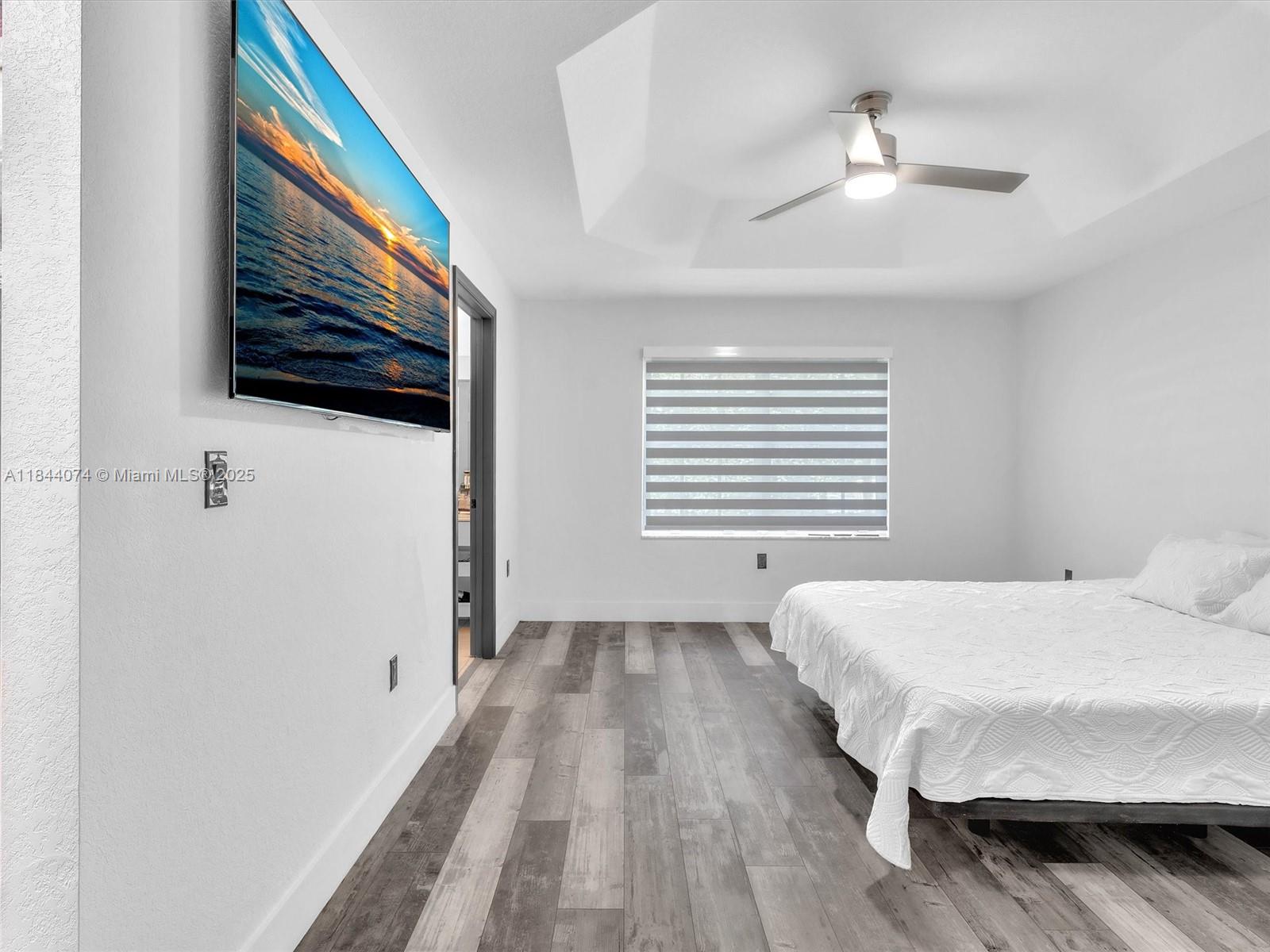 4331 Southwest 124th Way Miramar, FL 33027 - Photo 37 of 58 a bedroom with a bed a flat screen tv and a chandelier