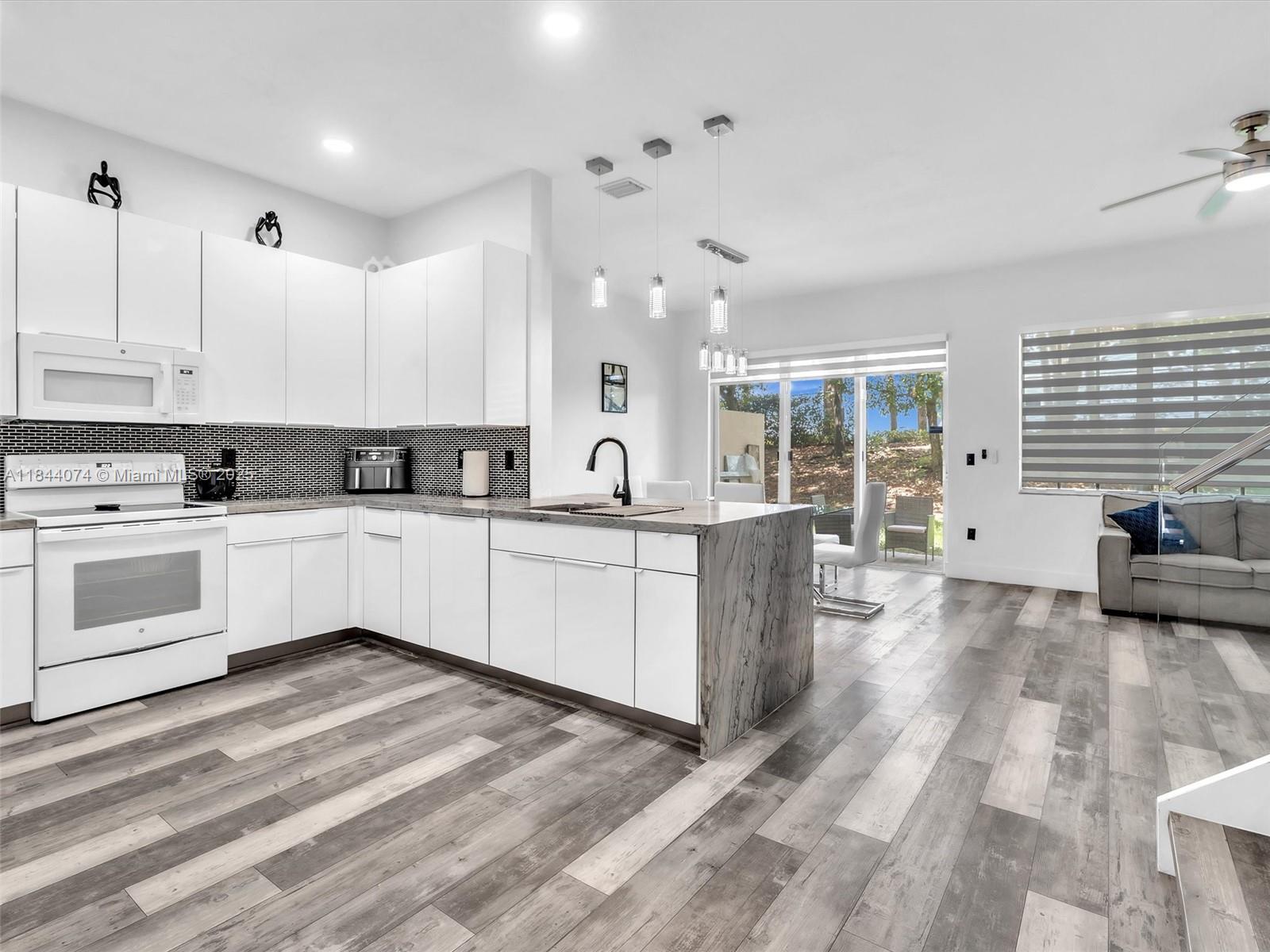 4331 Southwest 124th Way Miramar, FL 33027 - Photo 8 of 58 a kitchen with white cabinets and white appliances