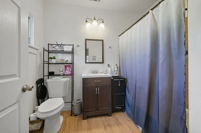 a bathroom with a toilet sink vanity and mirror