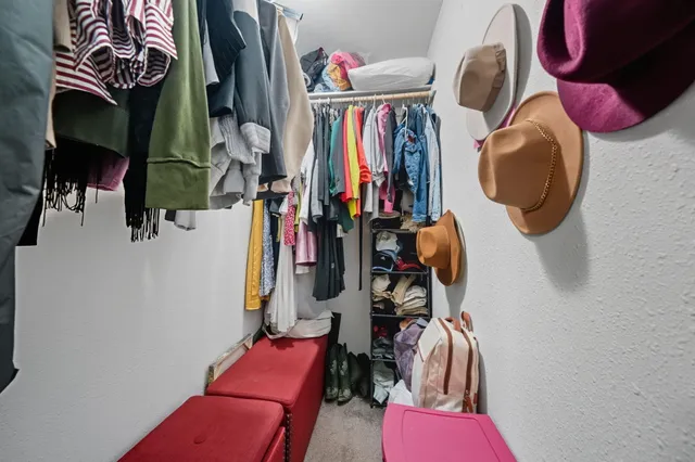 a view of walk in closet with clothes and shoes