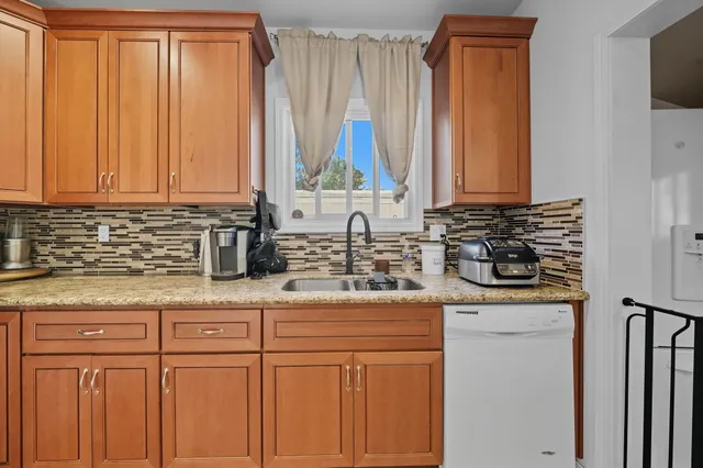 a kitchen with stainless steel appliances granite countertop a sink a stove and a microwave