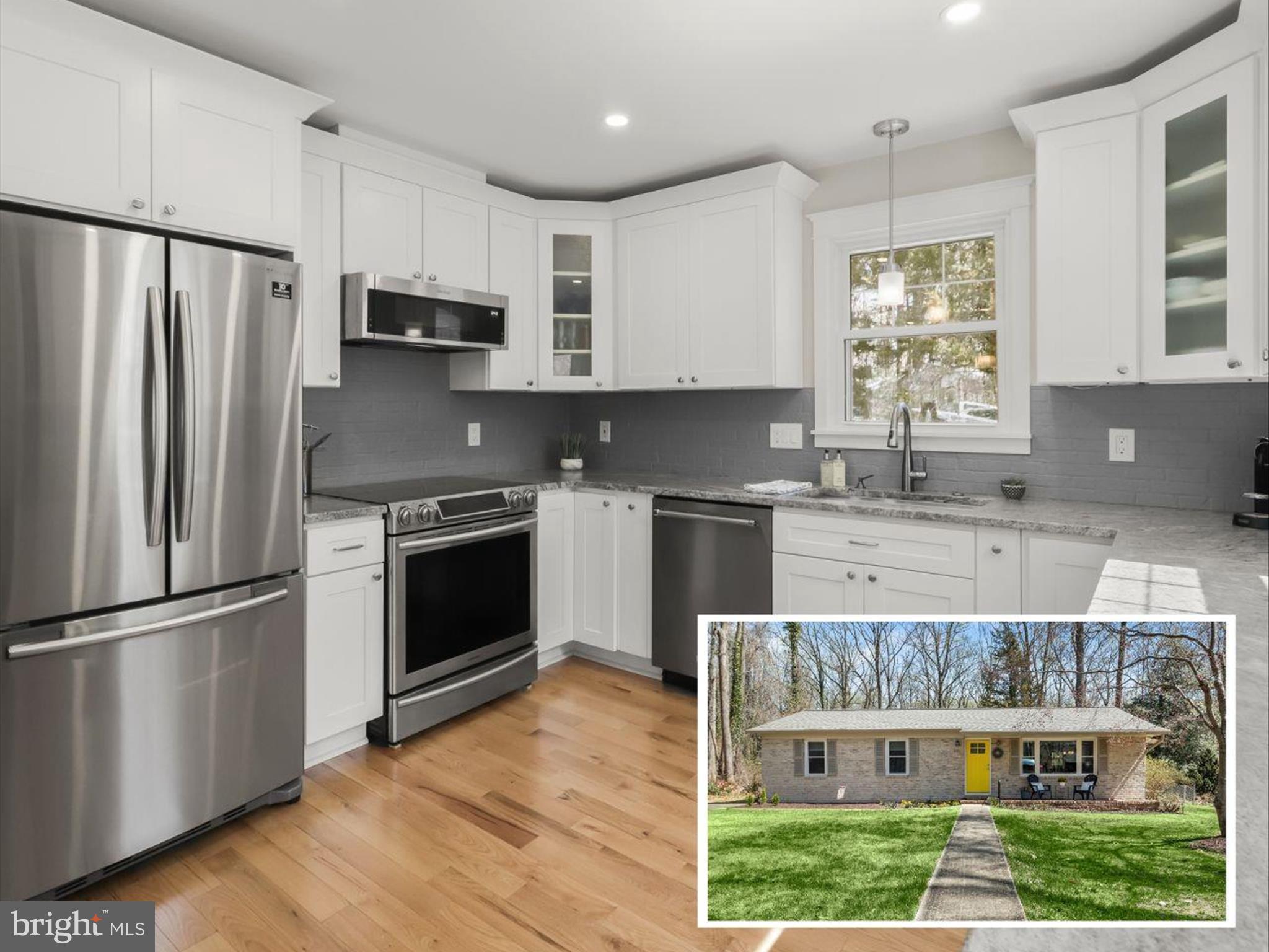 a kitchen with kitchen island granite countertop a stove a sink dishwasher a refrigerator and cabinets with wooden floor