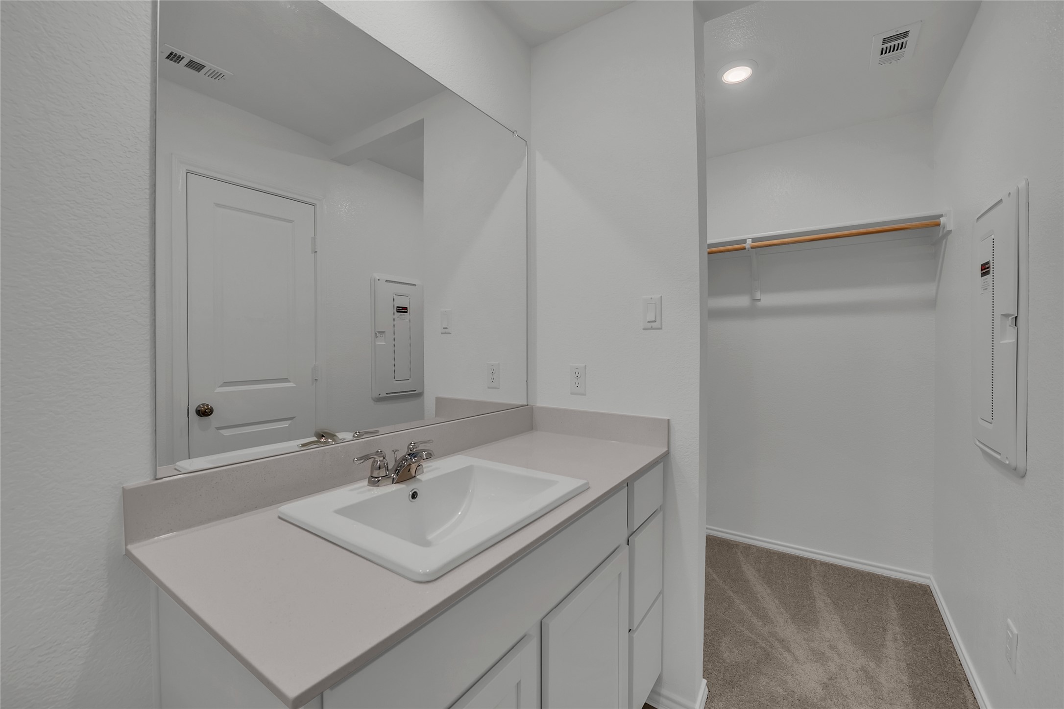309 Marty Allen Loop Jarrell, TX 76537 - Photo 18 of 33 Bathroom vanity with integrated sink, chrome faucet, and a large wall-mounted mirror