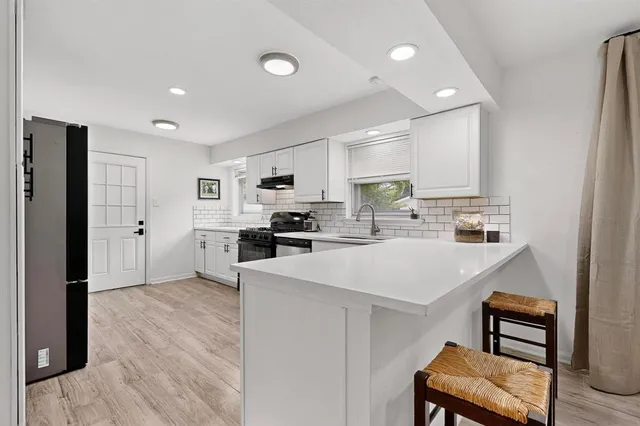 a kitchen with stainless steel appliances a refrigerator and a stove top oven