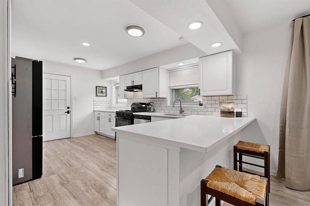 a kitchen with stainless steel appliances a refrigerator and a stove top oven