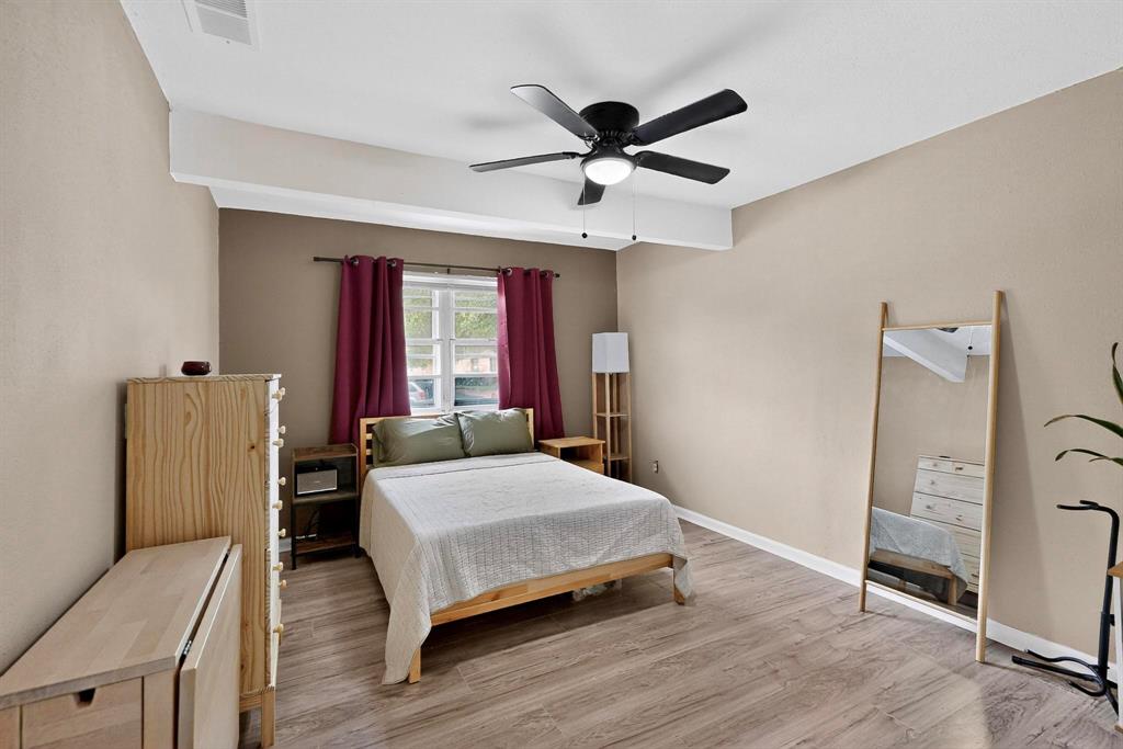 10834 Cassandra Way Dallas, TX 75228 - Photo 10 of 20 a bedroom with a bed and wooden floor