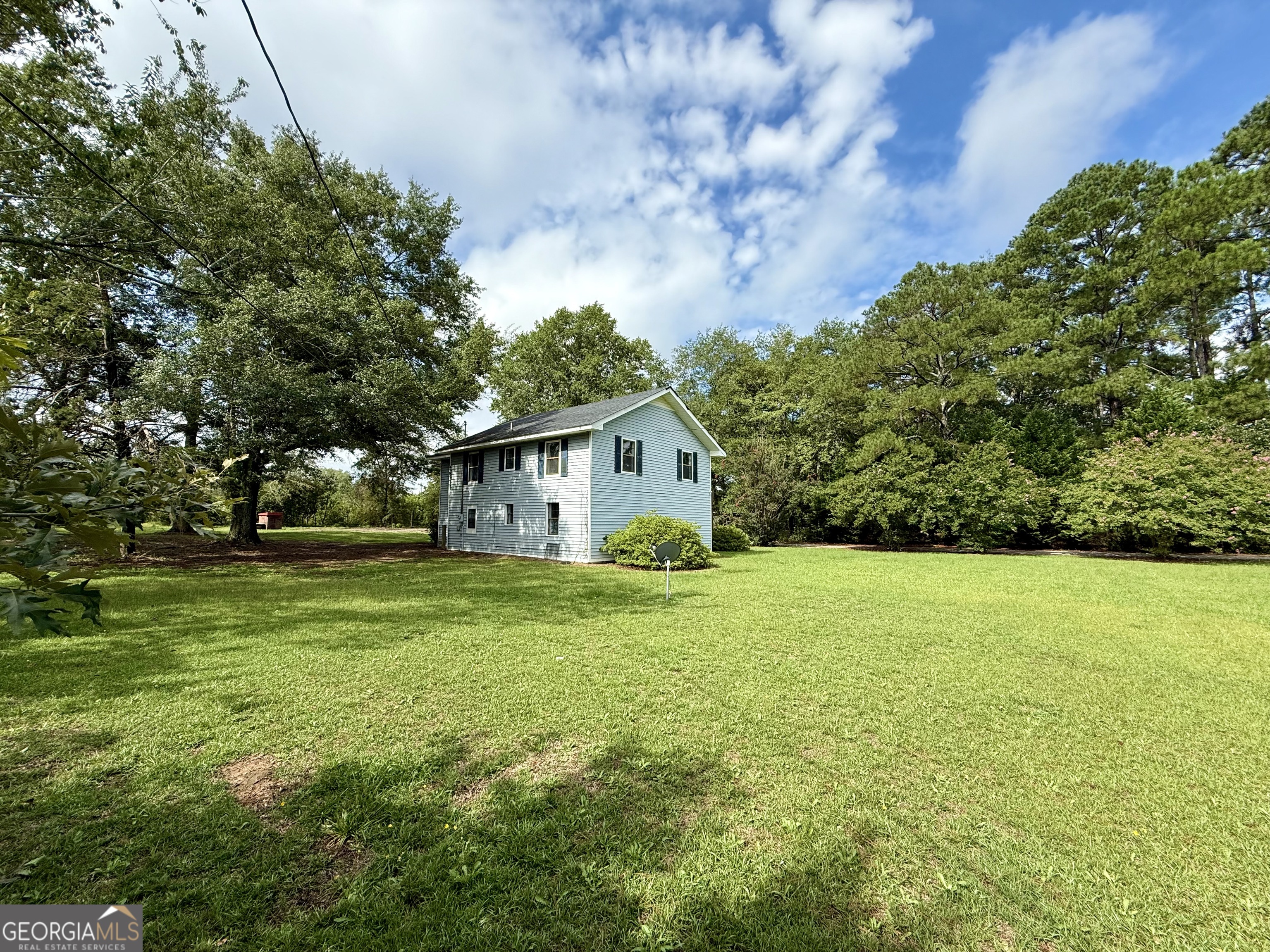 2592 White Oak Road Thomson, GA 30824 - Photo 26 of 30 a backyard of a house with plants and large trees
