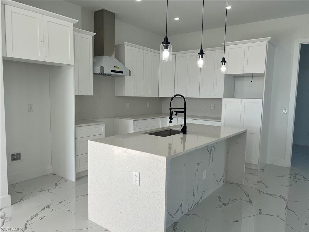 3510 15th Street Southwest Lehigh Acres, FL 33976 - Photo 22 of 50 Kitchen with white cabinets, sink, a kitchen island with sink, and wall chimney range hood