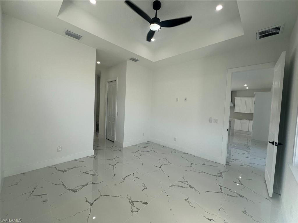 3510 15th Street Southwest Lehigh Acres, FL 33976 - Photo 32 of 50 Empty room with a tray ceiling and ceiling fan