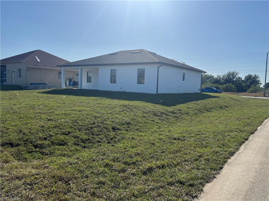 3510 15th Street Southwest Lehigh Acres, FL 33976 - Photo 41 of 50 View of side of property with a lawn
