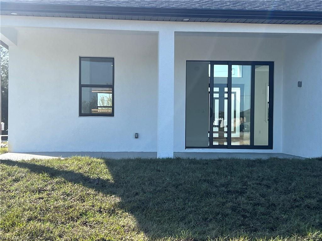 3510 15th Street Southwest Lehigh Acres, FL 33976 - Photo 42 of 50 View of exterior entry featuring a lawn