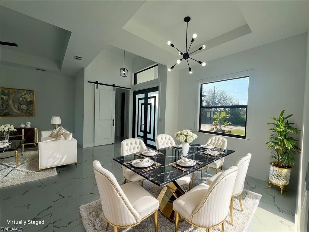 3510 15th Street Southwest Lehigh Acres, FL 33976 - Photo 10 of 50 Dining room with a raised ceiling, visible vents, marble finish floor, and a barn door