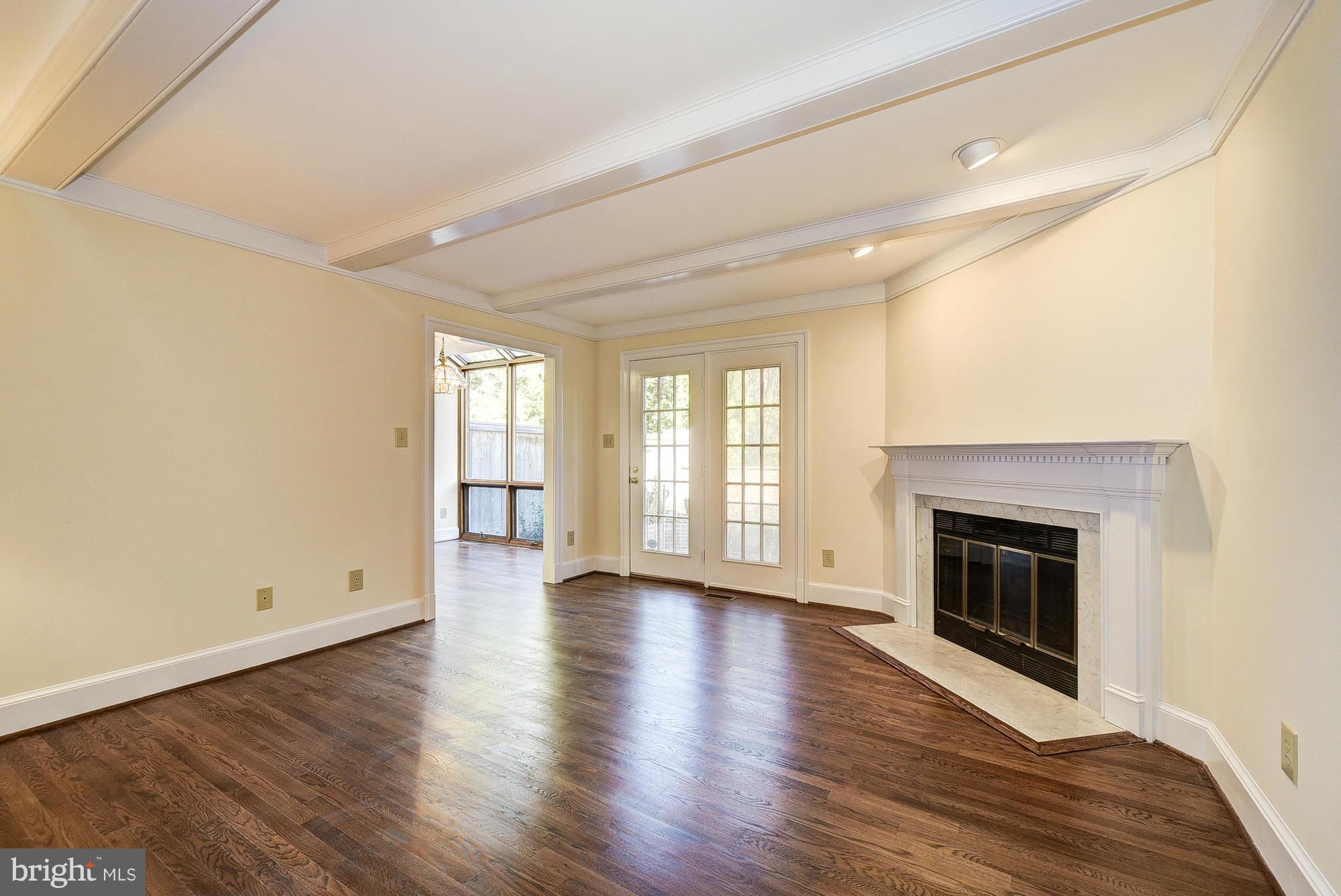 8023 Rising Ridge Road Bethesda, MD 20817 - Photo 11 of 30 an empty room with wooden floor fireplace and windows
