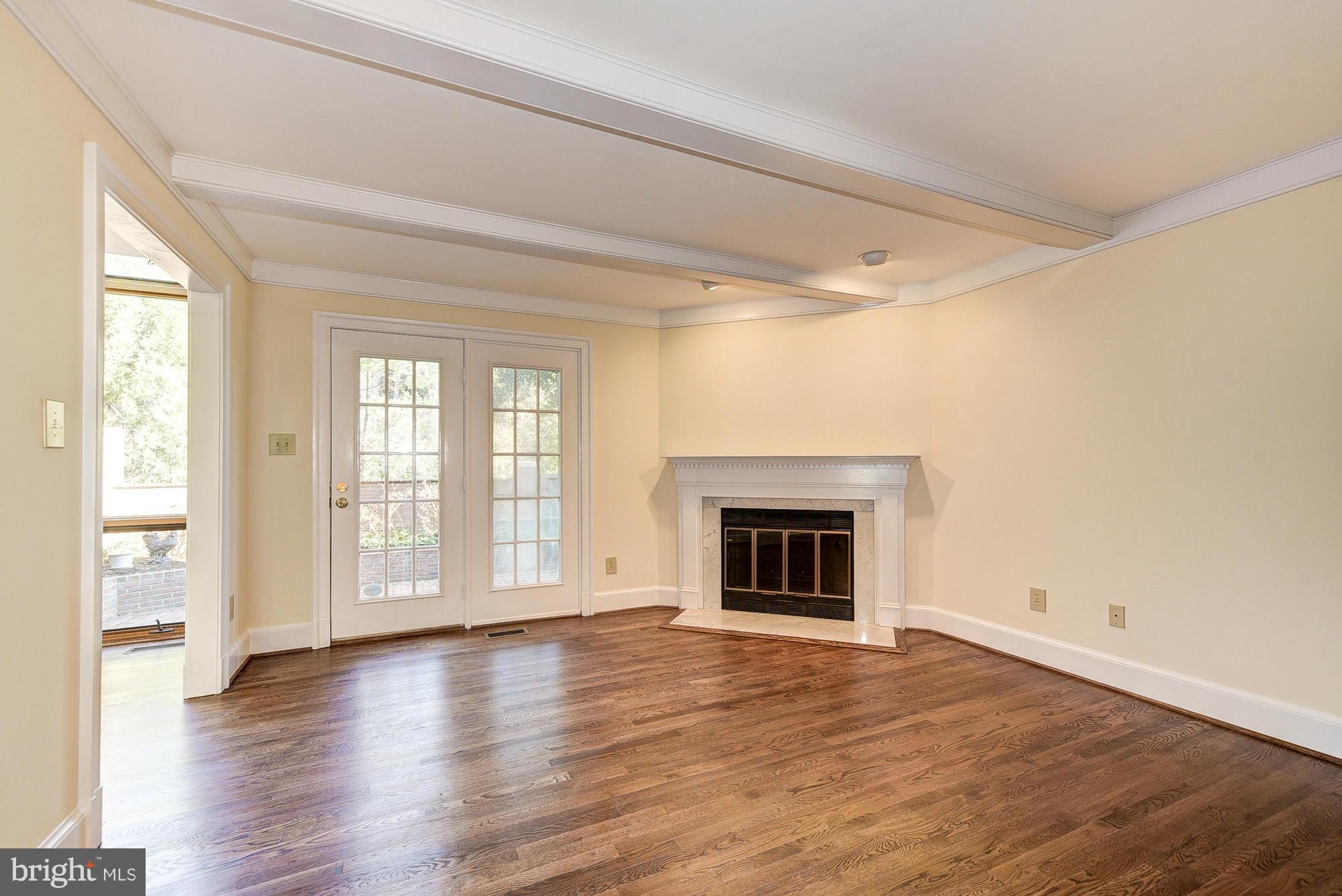 8023 Rising Ridge Road Bethesda, MD 20817 - Photo 12 of 30 an empty room with wooden floor fireplace and windows