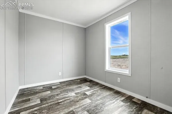 a view of empty room with wooden floor
